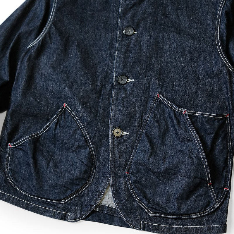 Japanese indigo denim utility chore jacket with curved patch pockets and contrast white stitching part of front view