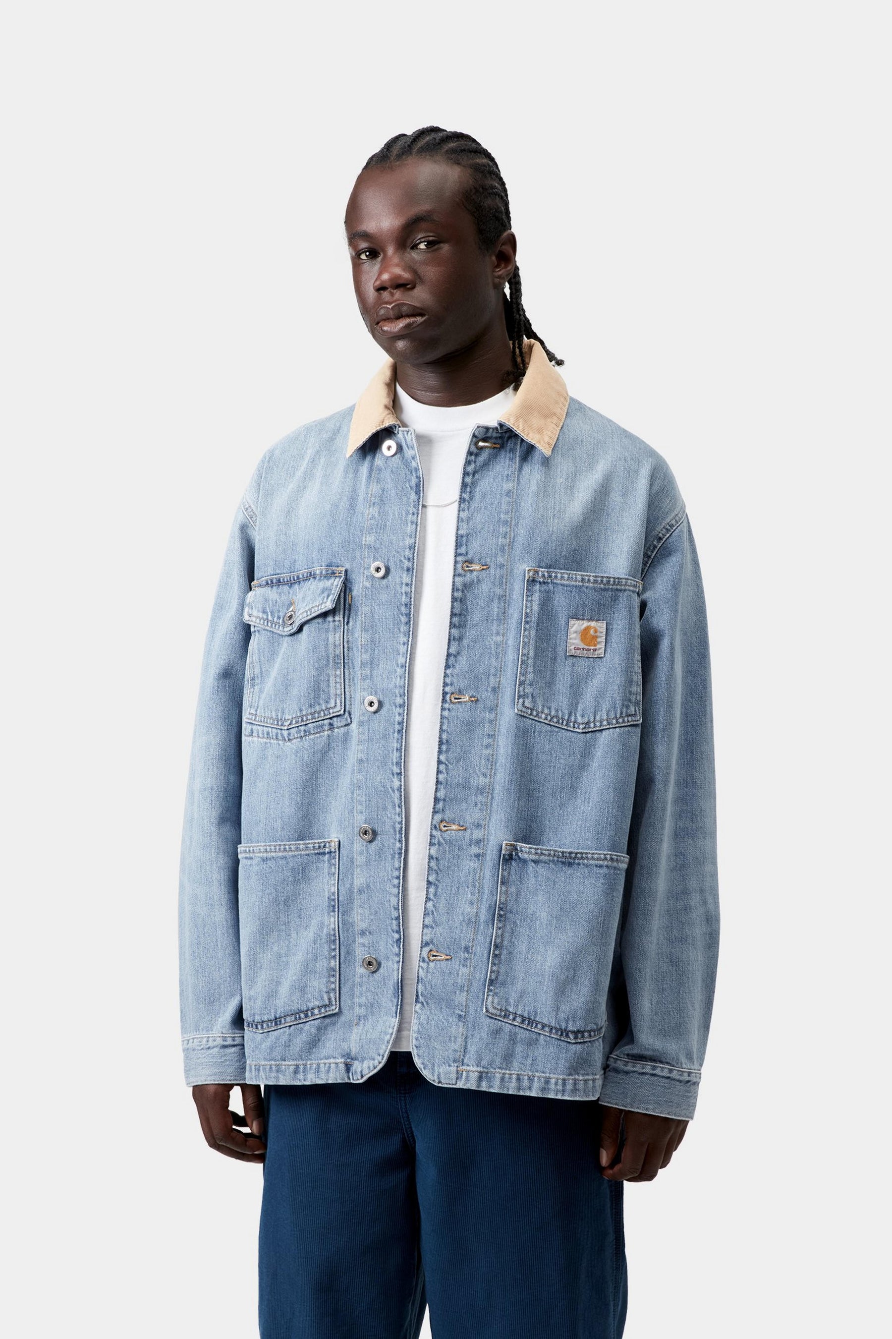 Model wearing a men's blue and dusty brown burst wash chore coat with relaxed workwear styling