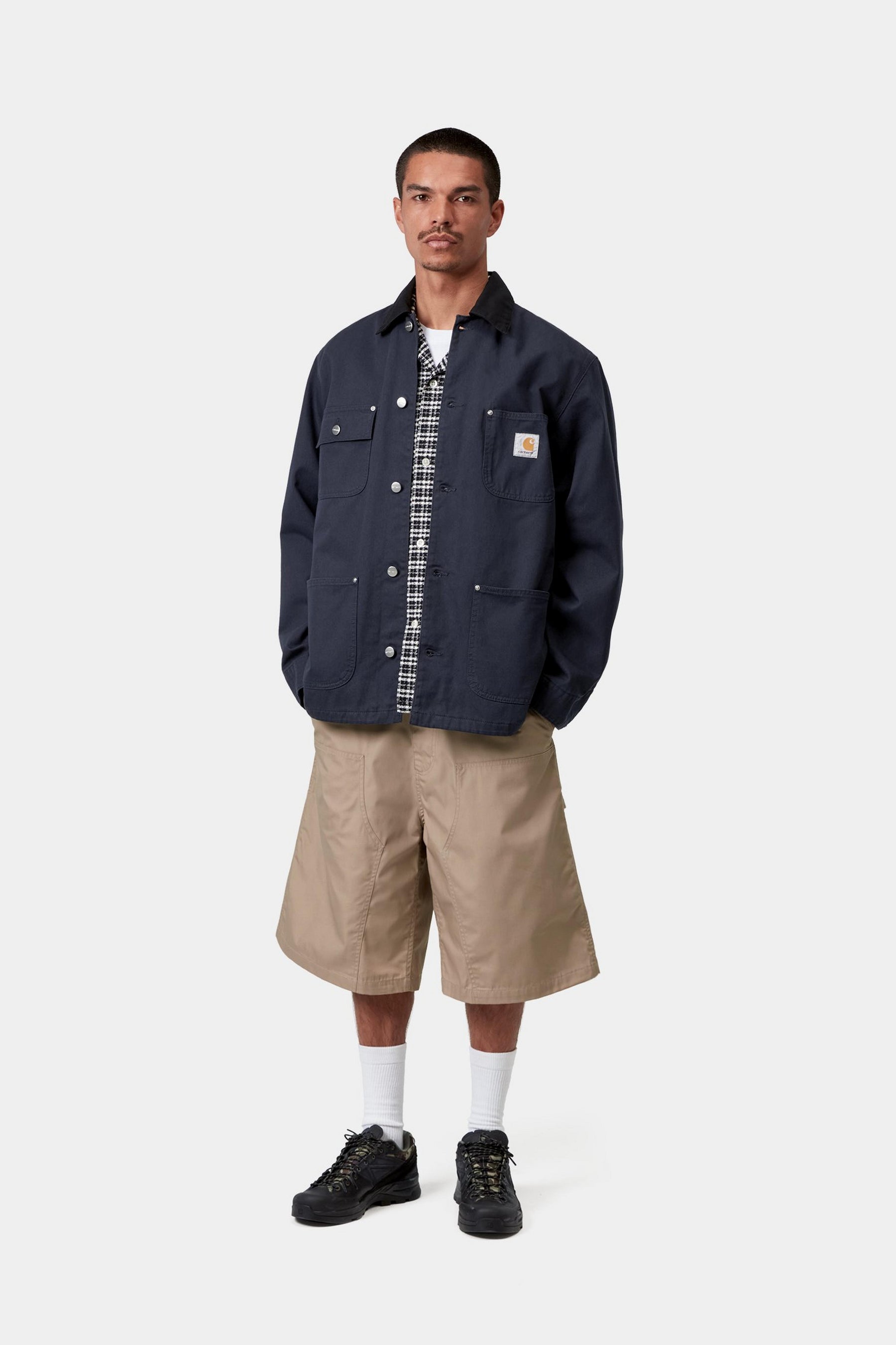 Model wearing a deep night black chore jacket in a casual layered workwear look