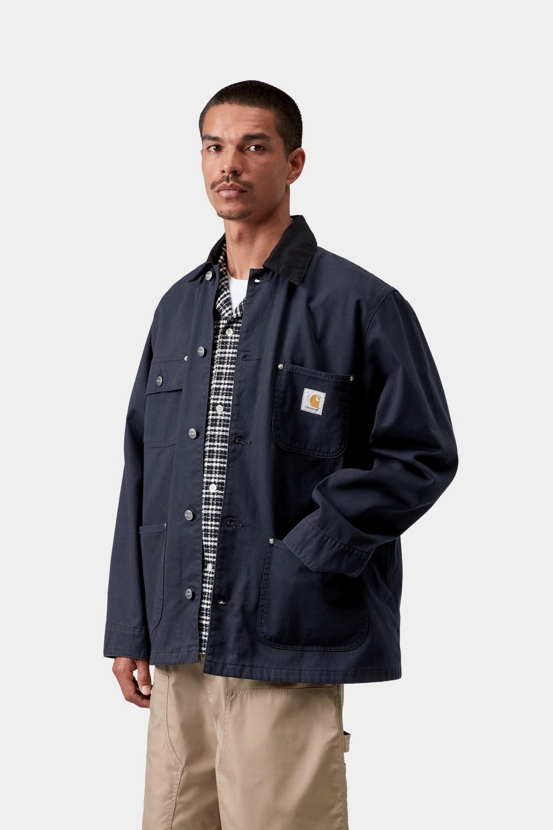 Model wearing a men's deep night black rinsed chore coat with relaxed workwear styling